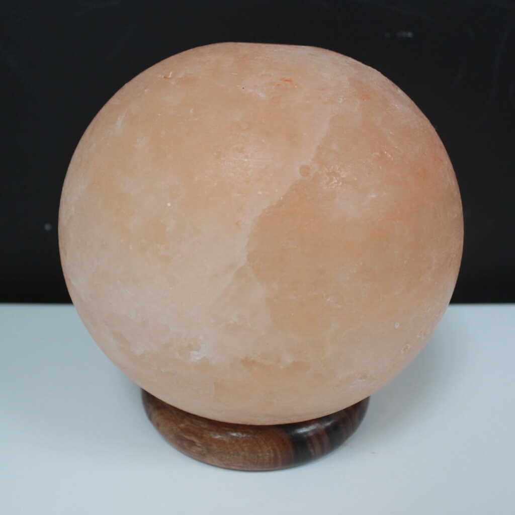an Himalayan salt lamp ball on a wooden base