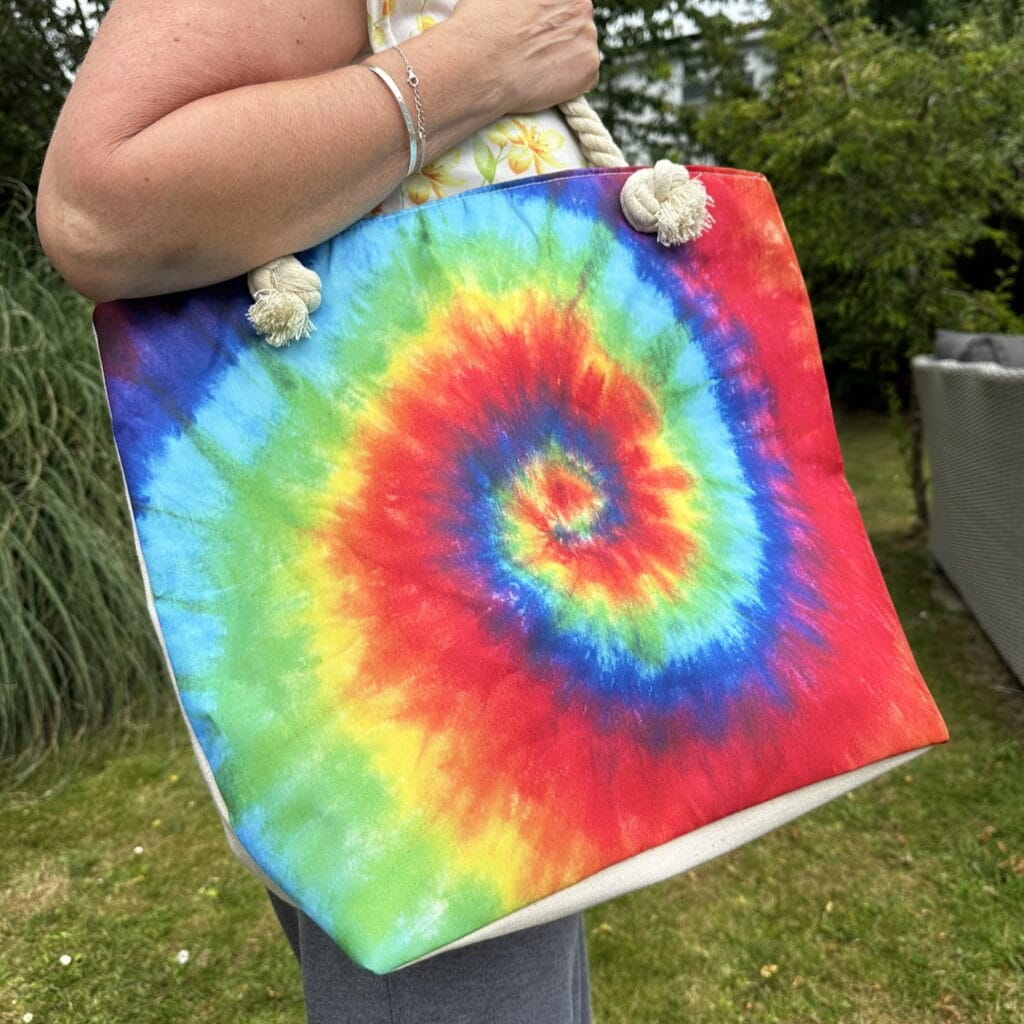 tina holding a psychedelic splash bag in bright spiral colours - pure energy