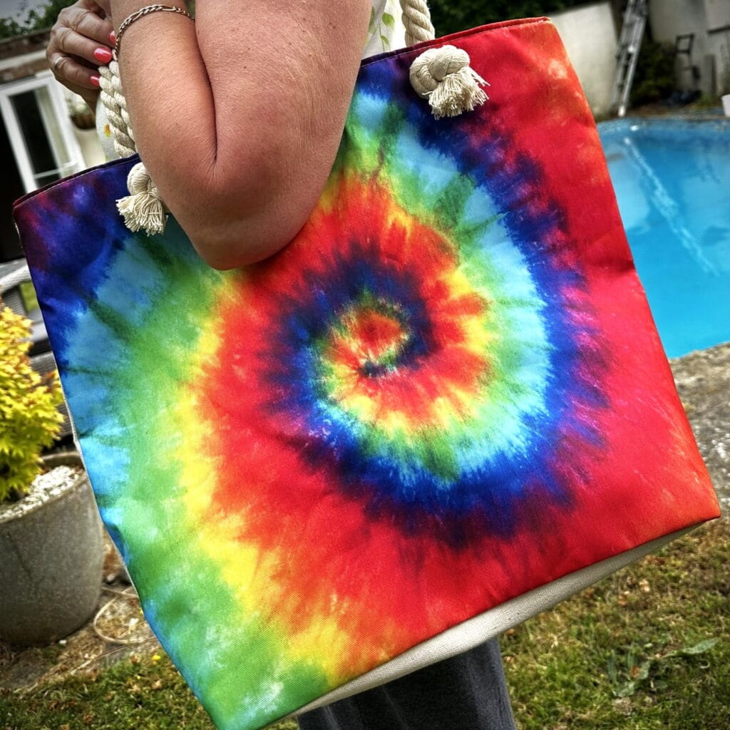 tina holding a psychedelic splash bag in bright spiral colours - pure energy