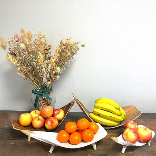 a set of four coconut leaf fruit bowls. on a table