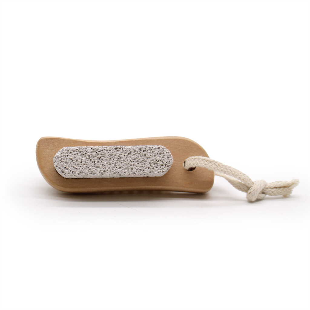 a face and body brush with a brush on top and a stone on the bottom - showing the stone