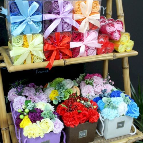 a selection of soap flowers on a set of shelves