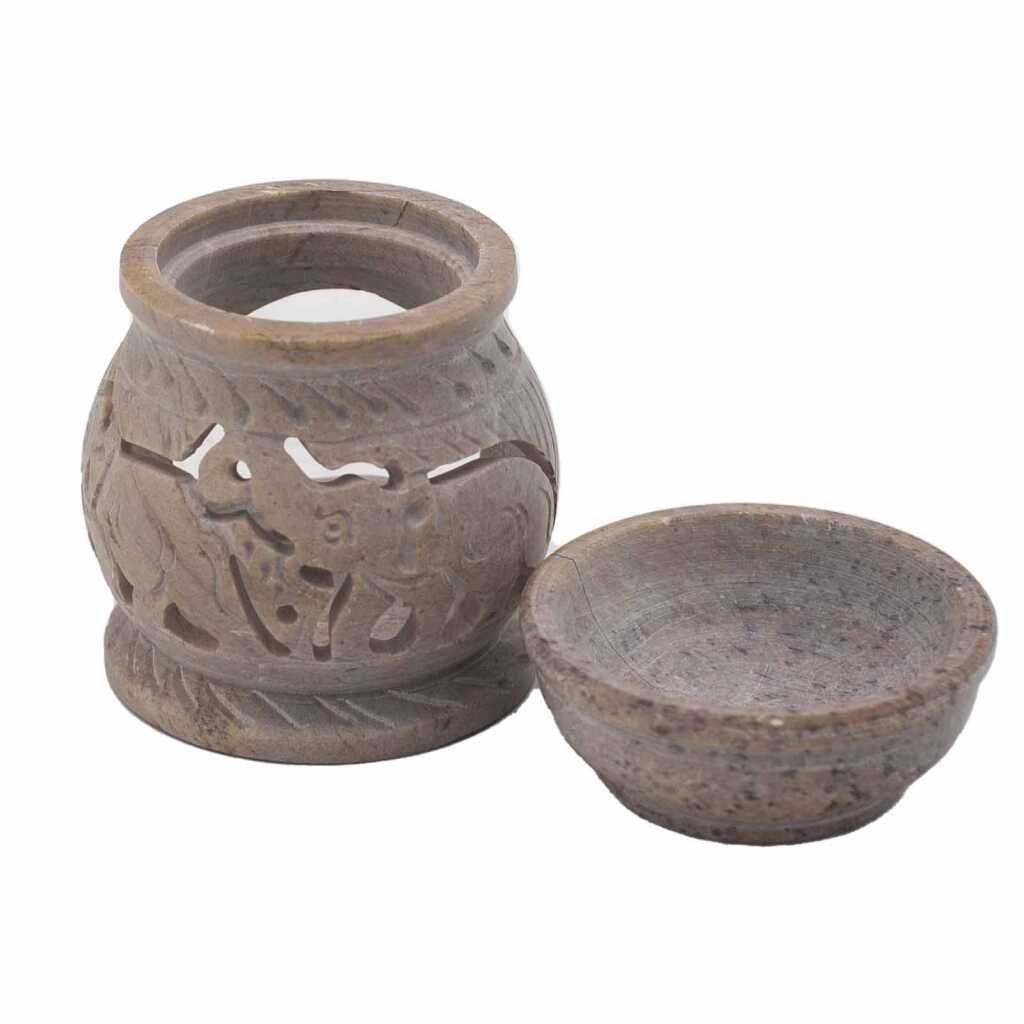 a soapstone oil burner with an elephant design, showing the two parts, base and top bowl.