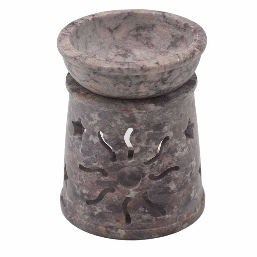 a soapstone oil burner with a sun and stars design.
