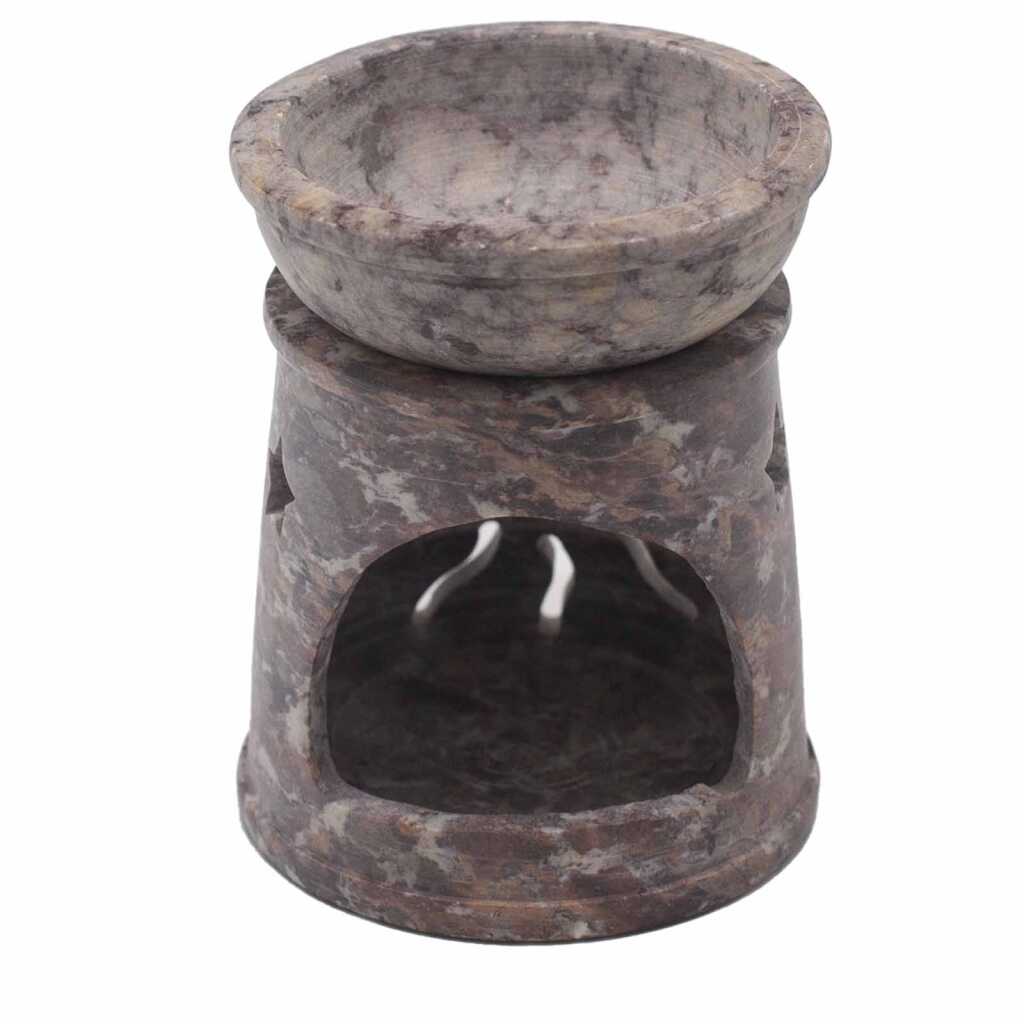 a soapstone oil burner with a sun and stars design.