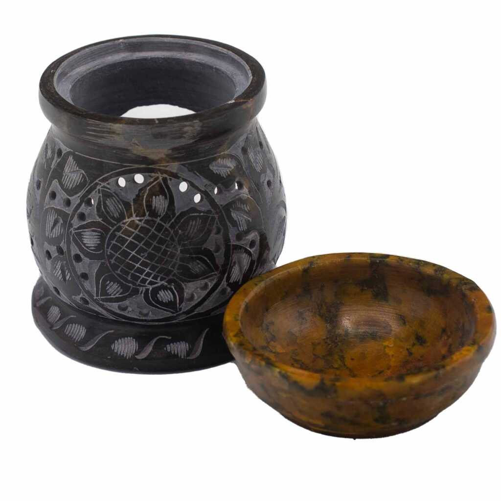 a yellow and black soapstone oil burner with a mandala flower design, showing the base and the top bowl separately.