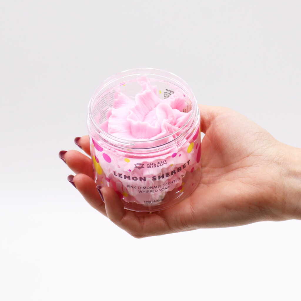 lemon sherbet / pink lemonade whipped soap - pink - in an open container, in an open hand