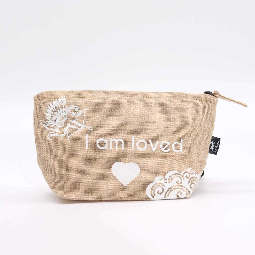 A jute pouch with the words "I am loved" written on the side.