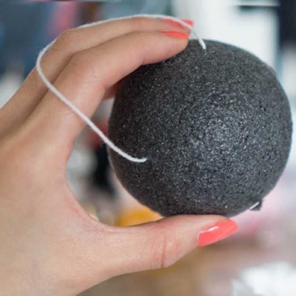 a charcoal coloured konjac sponge on a string loop