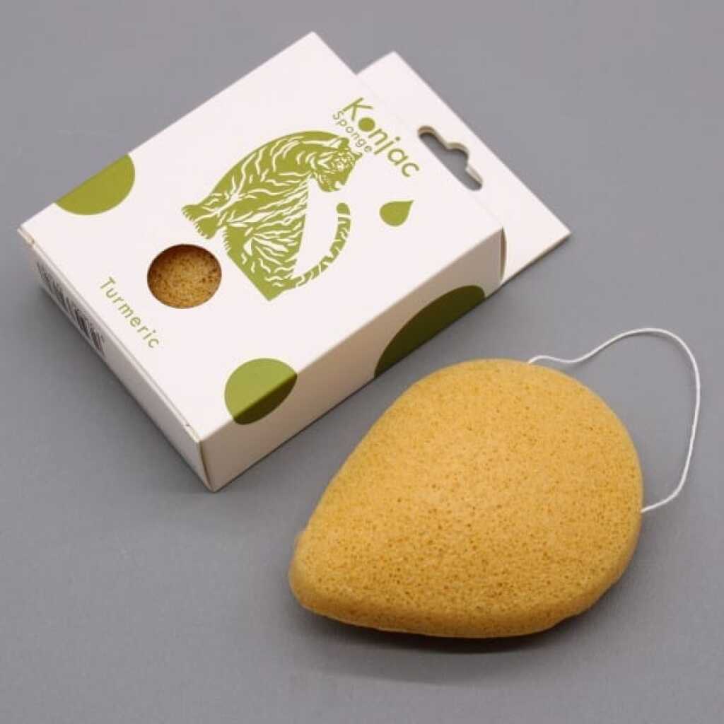 a yellow teardrop konjac sponge infused with turmeric beside its box