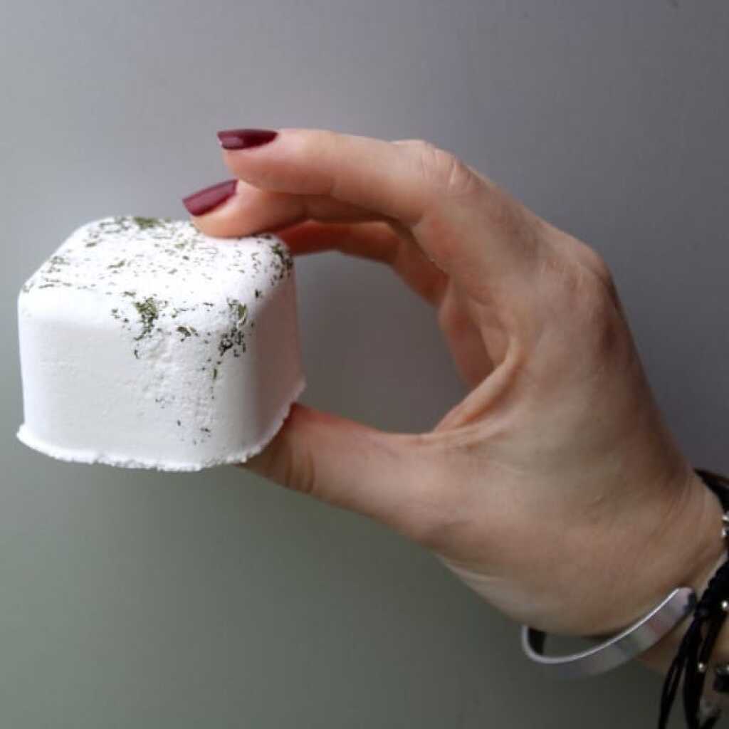 Peppermint and Eucalyptus shower steamer between fingers and thumb - Kick Start