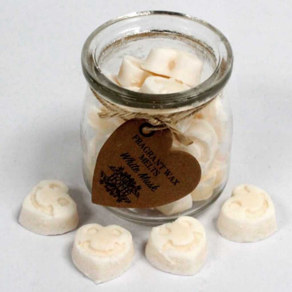 a jar of soy wax melts with four in front - white musk