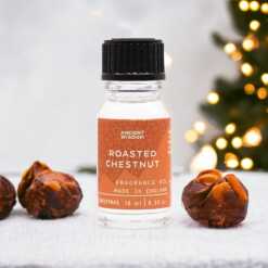 a 10ml clear bottle of Roasted Chestnut fragrance oil in a christmas setting