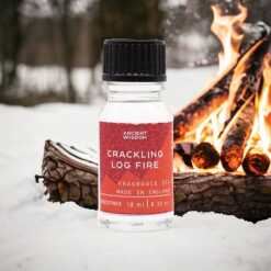 a 10ml clear bottle of Crackling log Fire fragrance oil in a christmas setting