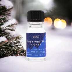 a 10ml clear bottle of Cosy Winter Nights fragrance oil in a christmas setting