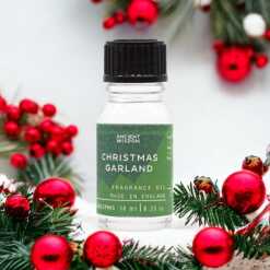 a 10ml clear bottle of Christmas Garland fragrance oil in a christmas setting