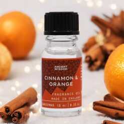 a 10ml clear bottle of Cinnamon and Orange fragrance oil in a christmas setting