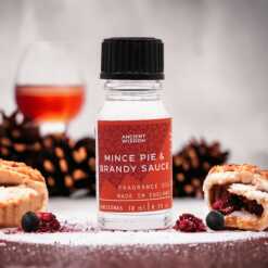 a 10ml clear bottle of Mince Pie and Brandy Sauce fragrance oil in a christmas setting