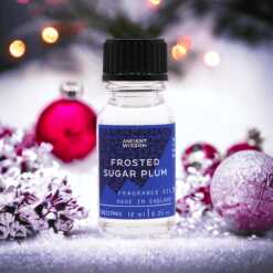 a 10ml clear bottle of Frosted Sugar Plum fragrance oil in a christmas setting
