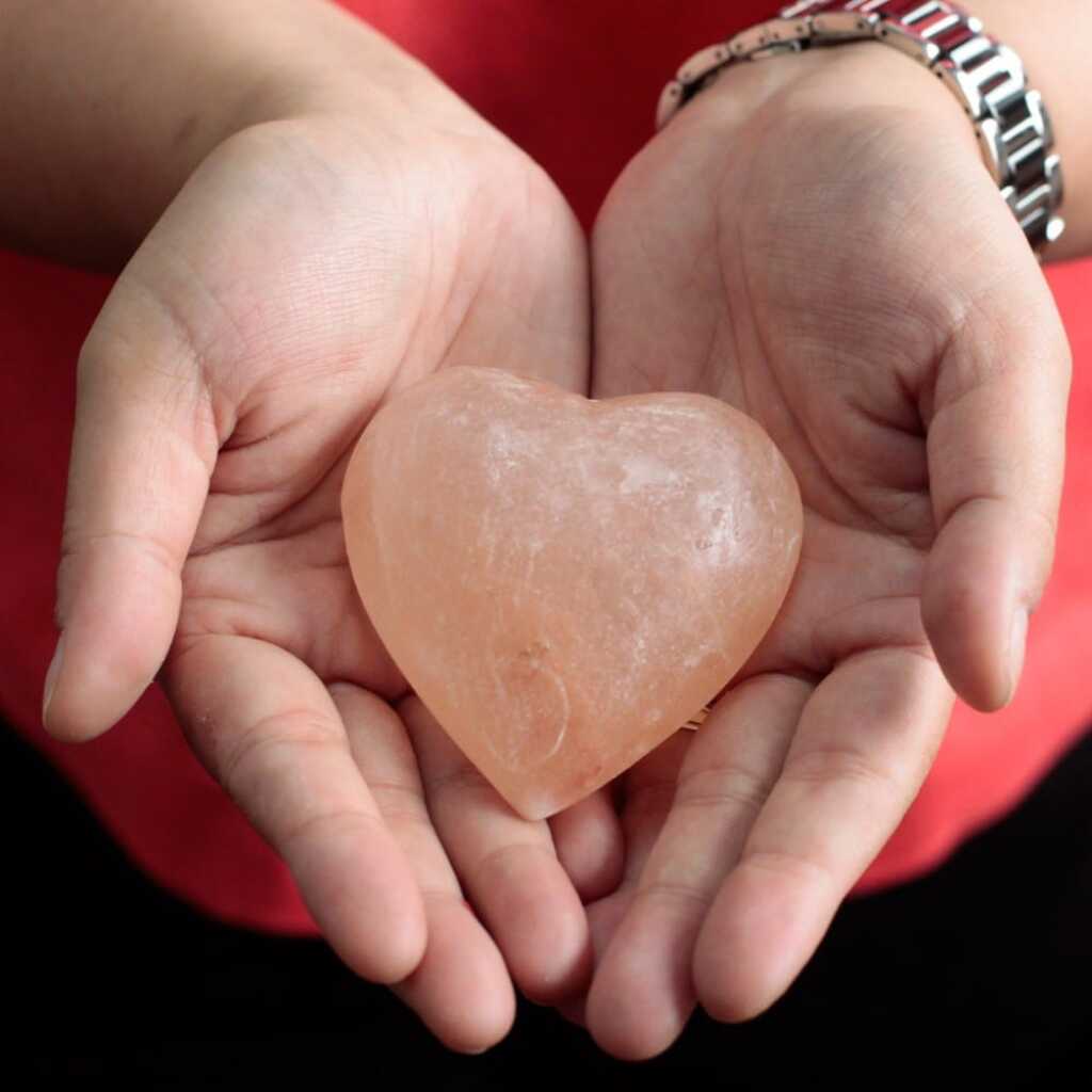 one heart shaped himalayan salt deodorant stone held in two hands