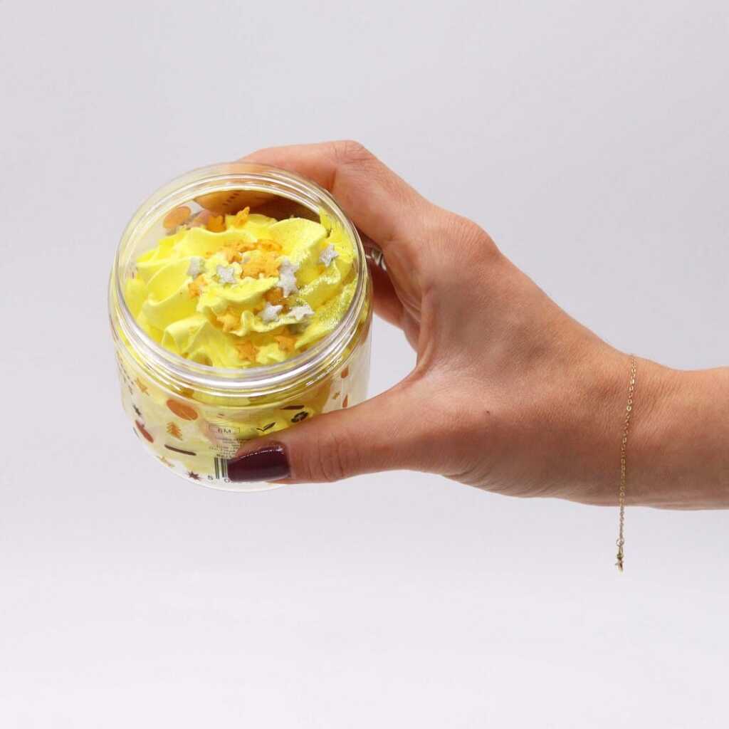 an open jar of Cosy Winter Nights whipped soap, held between thumb and fingers