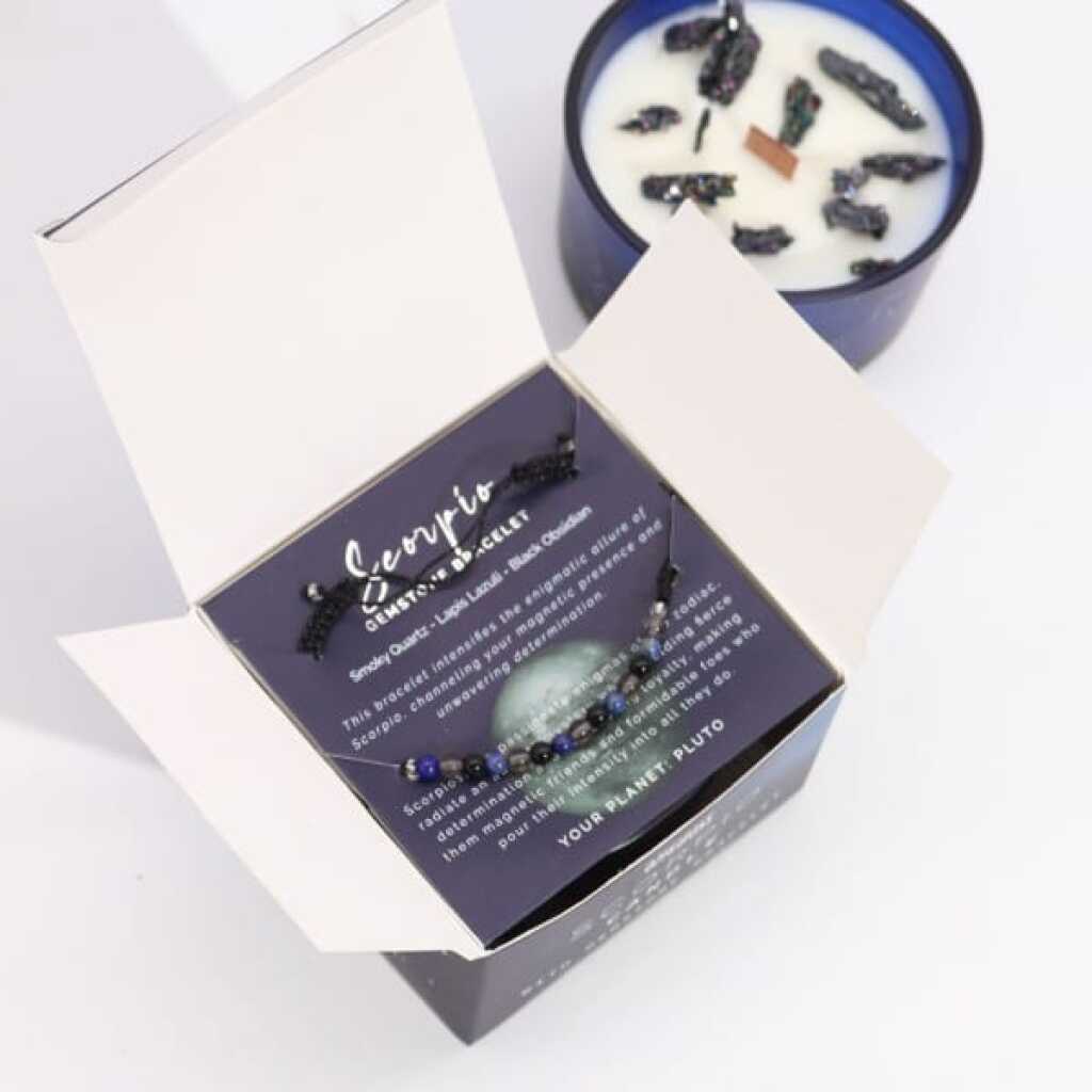 a zodiac candle with crystals and a gemstone bracelet - scorpio