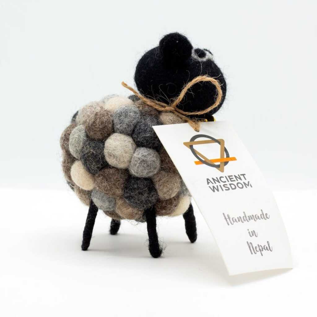 a little felt sheeps in various shades of grey with a black head with a label around its neck