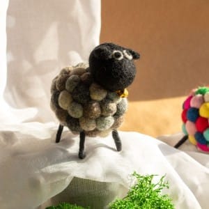 a grey felt sheeps with a black face