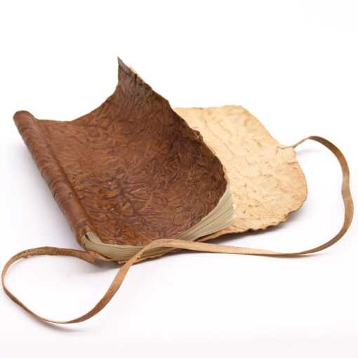 A rolled leather travel notebook, unrolled