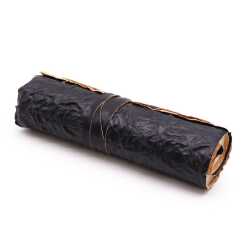 A rolled leather travel notebook in black, rolled up