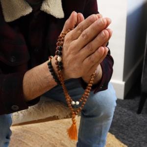 Bali Mala Necklace hanging on praying hands