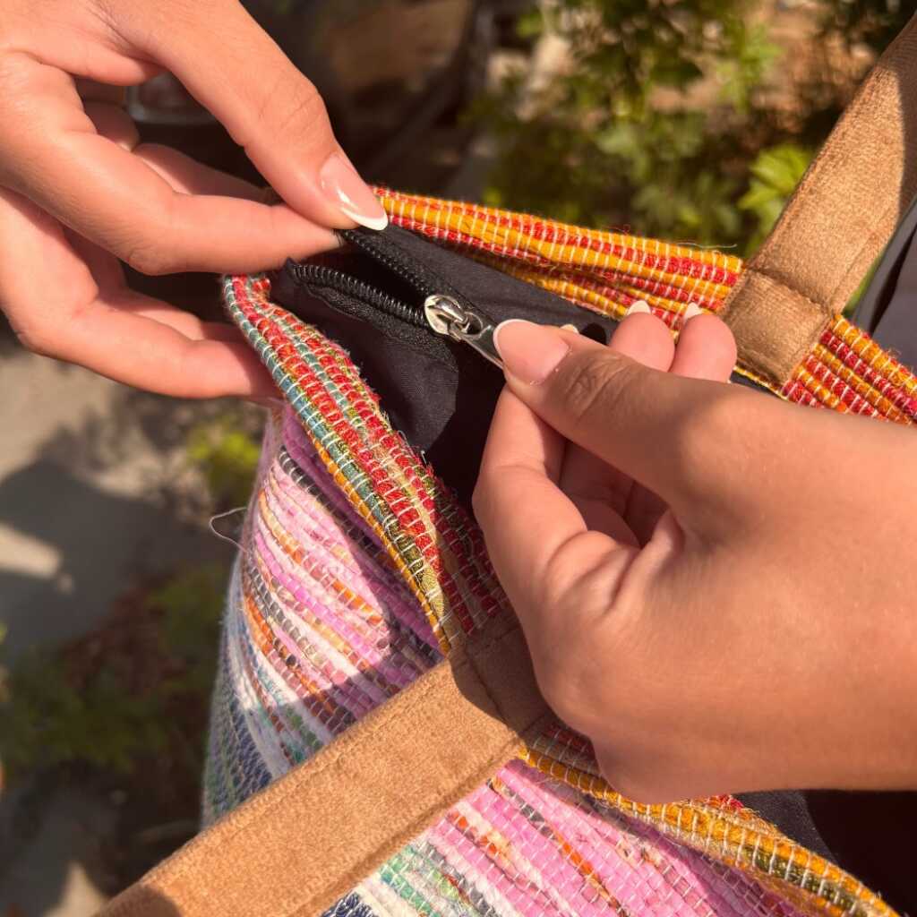 A big bag with stripes made from recycled rugs showing design details