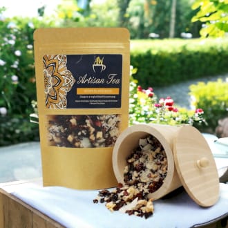 a pack of artisan tea alongside a wooden jar.