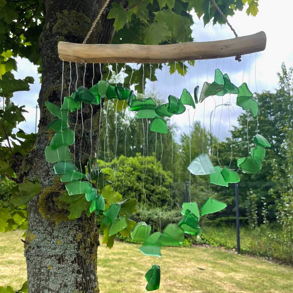 Driftwood and reclaimed glass wind chimes with one driftwood stick and a love heart made from green glass