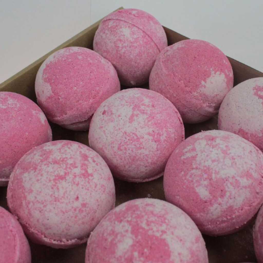 a collection of pink bath bombs in a tray