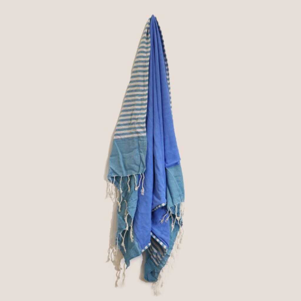 a sky blue cotton pareo towel, on a peg