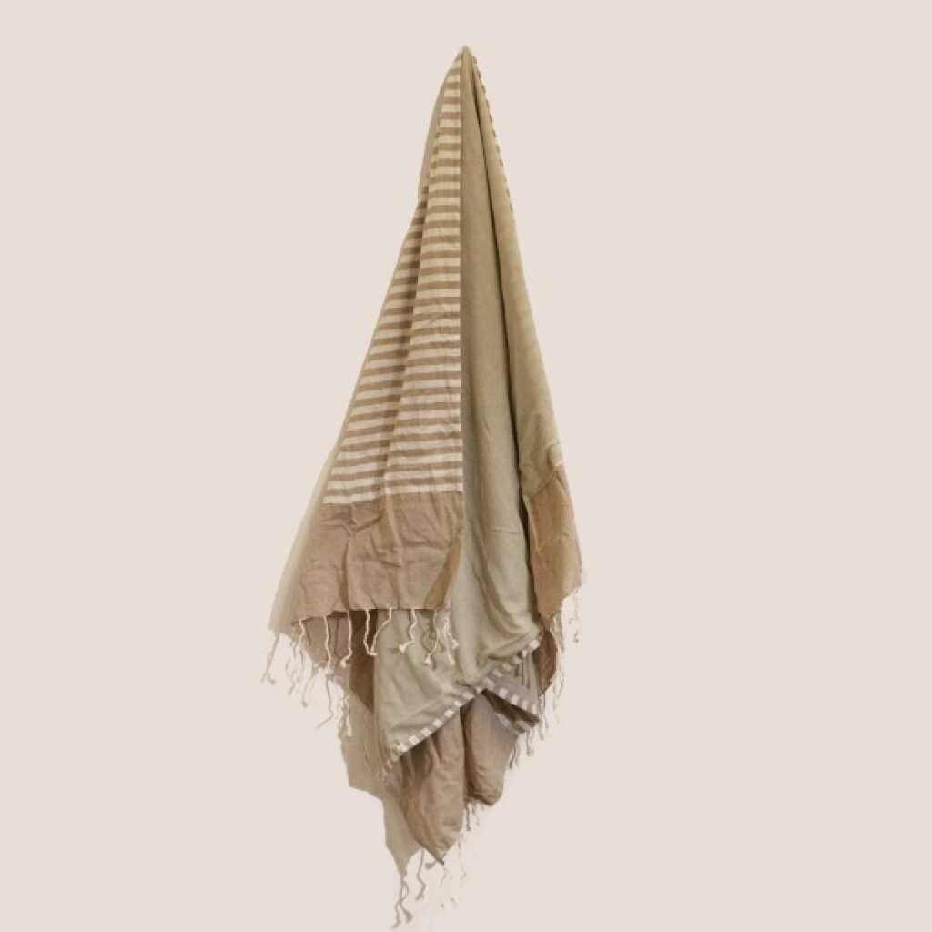 a warm sand cotton pareo towel, on a peg