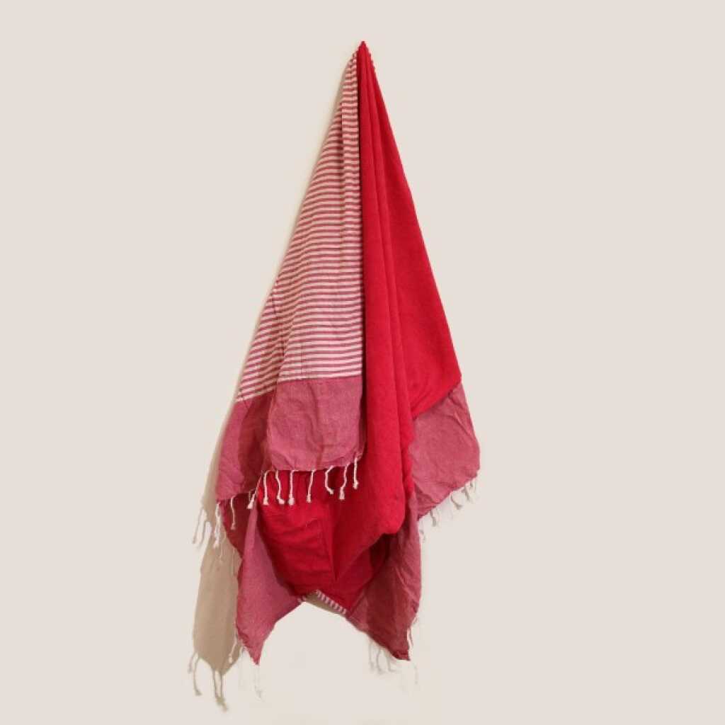 a hot pink cotton pareo towel, on a peg