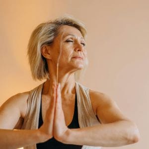 lady with hands together holding an incense stick