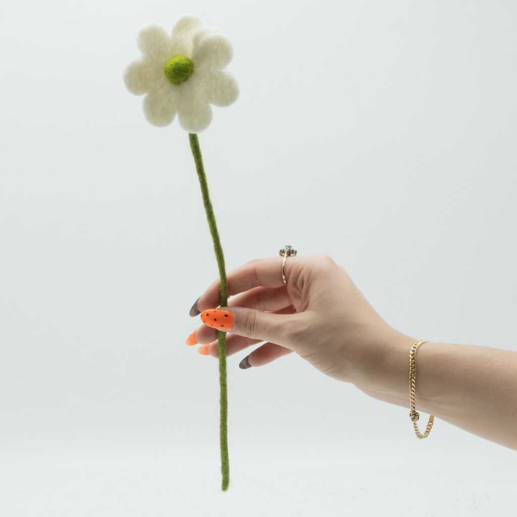 a white felt daisy on a stem