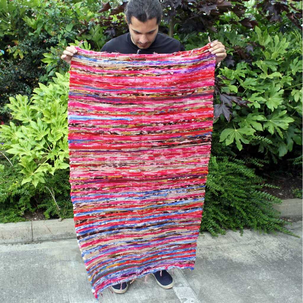 Indian Rag Rug being held up and outstetched by a man